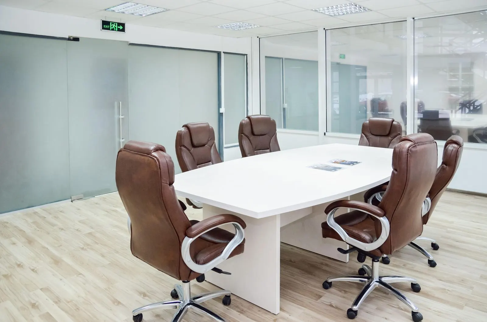Freshly cleaned office conference room with a white table and leather chairs